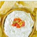 Homemade Casa Ole green sauce in a wood bowl and tortilla chips around it.