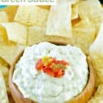 A bowl of homemade Casa Ole green sauce and tortilla chips around it.