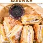 Homemade Cheddar's monte cristo sandwich and a small cup of raspberry jam.