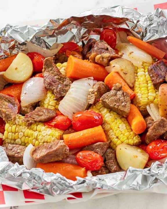 Copycat Cracker Barrel campfire beef meal in foil on a parchment paper lined platter.