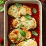 Four slices of eggplant parmesan in a baking dish.