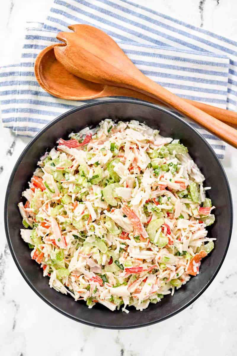 Copycat Golden Corral seafood salad in a large bowl and wooden salad tongs.