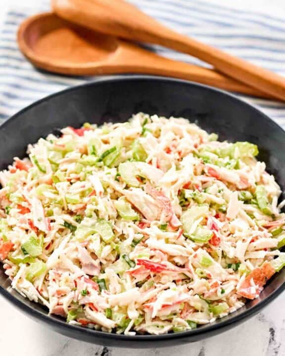 Copycat Golden Corral seafood salad in a large bowl and salad tongs behind it.