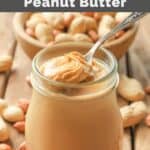 Homemade peanut butter in a jar and a bowl of peanuts.