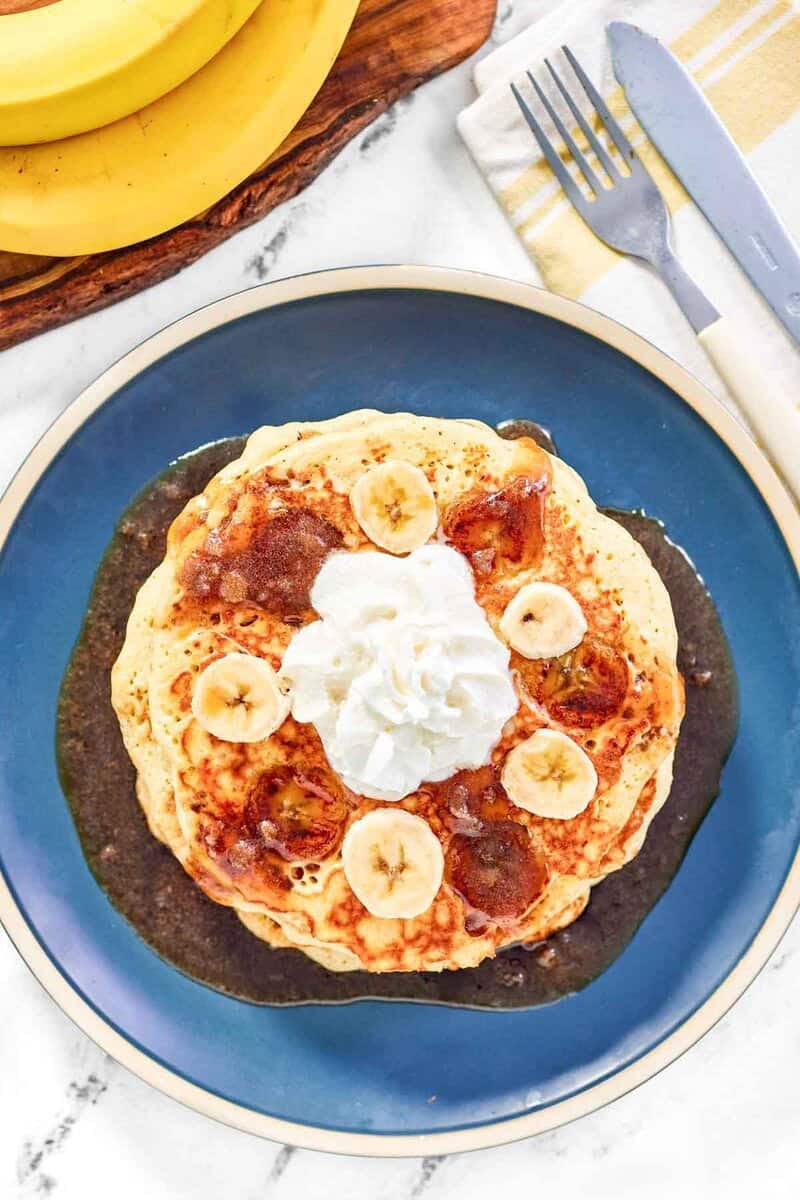 Copycat IHOP bananas foster pancakes, bananas, fork, and knife.