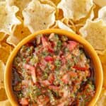 A bowl of copycat Pappasito's salsa and tortilla chips around it.