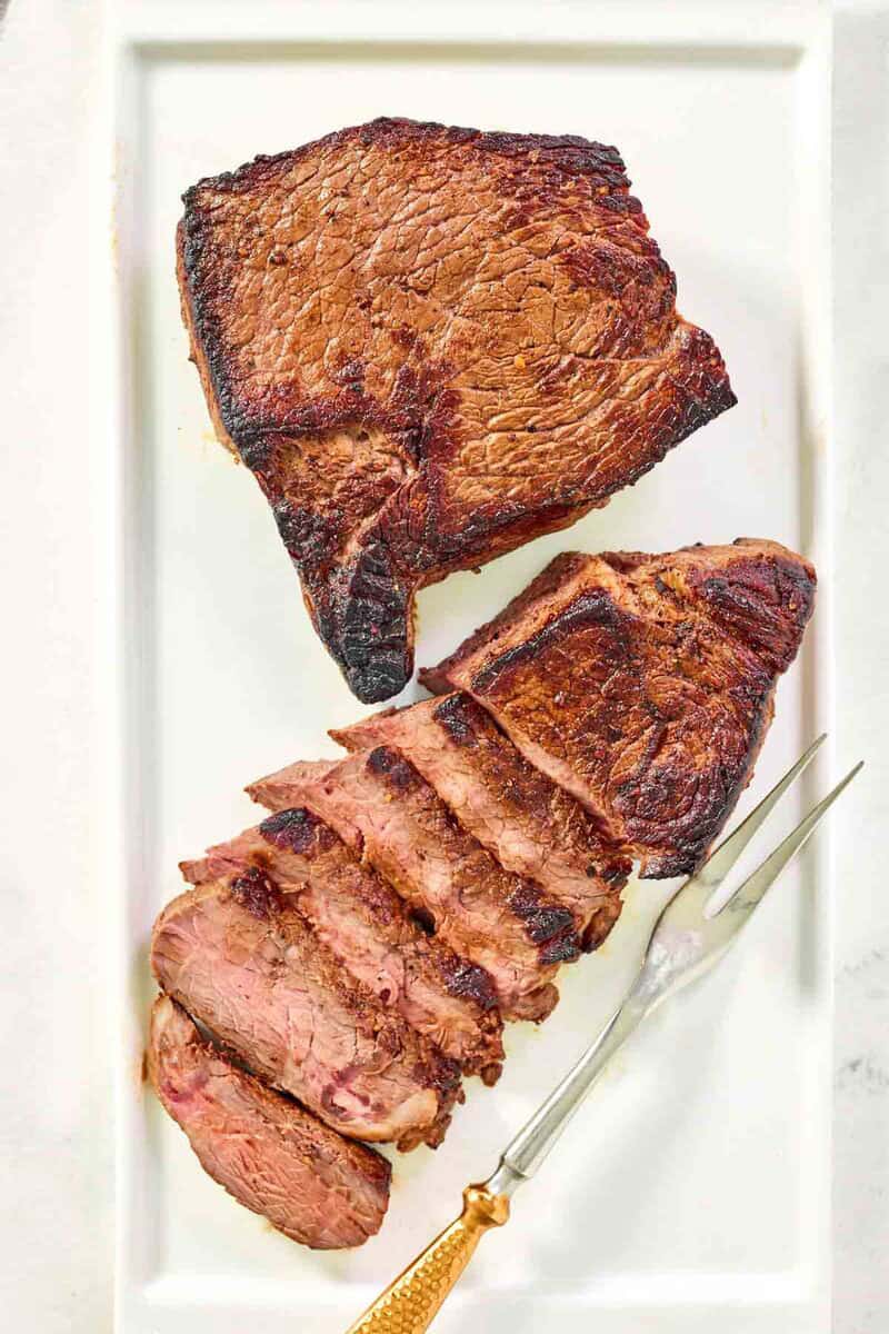 Two steaks made with copycat steak and ale kensington club marinade on a platter.