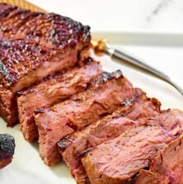 Steak made with copycat steak and ale kensington club marinade on a platter.