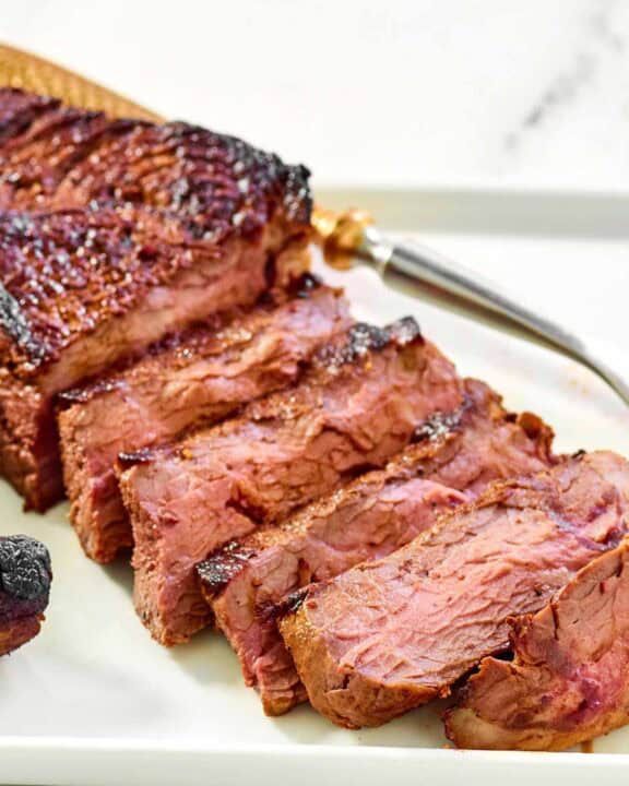 Steak made with copycat steak and ale kensington club marinade on a platter.