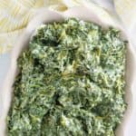 Copycat Boston Market creamed spinach in a ceramic baking dish.