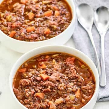 Copycat Carrabba's sausage lentil soup in two bowls.