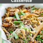 Hamburger green bean casserole on a wood spoon over the dish.