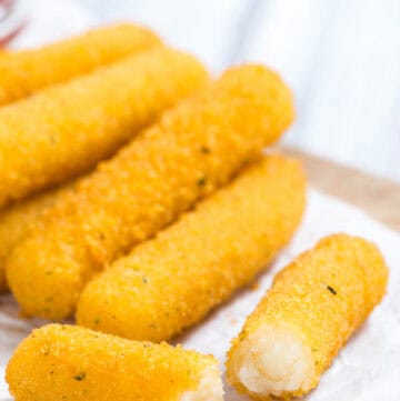 Smoked mozzarella cheese sticks on a wood board.