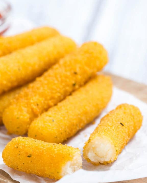Smoked mozzarella cheese sticks on a wood board.