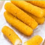 Homemade smoked mozzarella sticks on parchment paper.